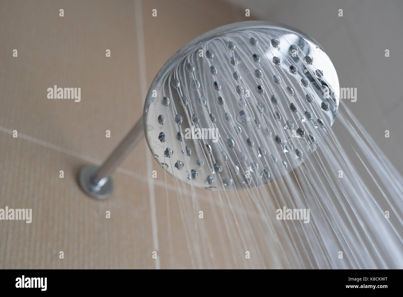 Photo de la tête de douche à l'eau courante dans la salle de bains (close up selective focus) Banque D'Images