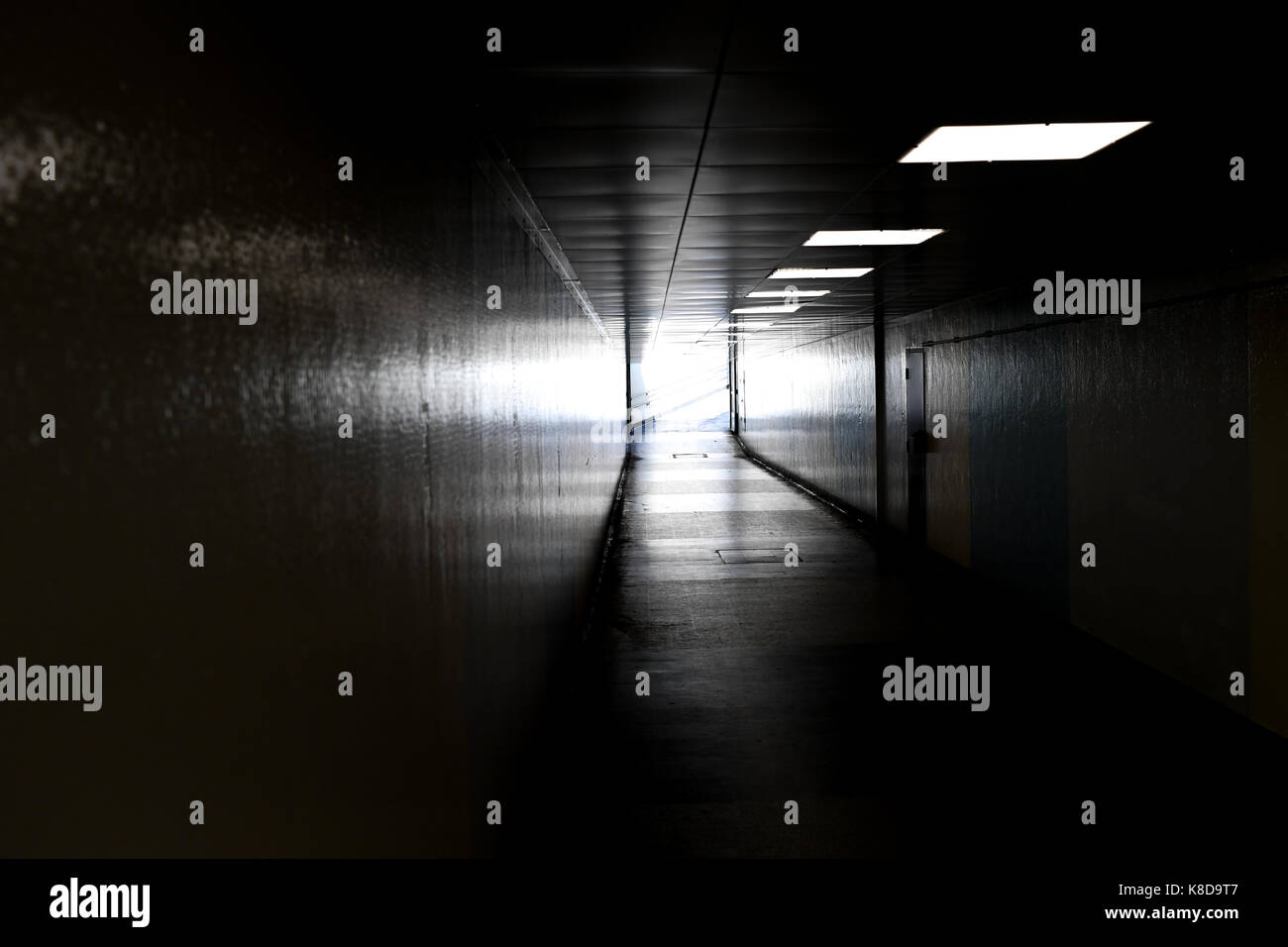 Vue vers le bas dans un sombre souterrain du métro menant à la sortie de lumière éclatant à partir de c Banque D'Images