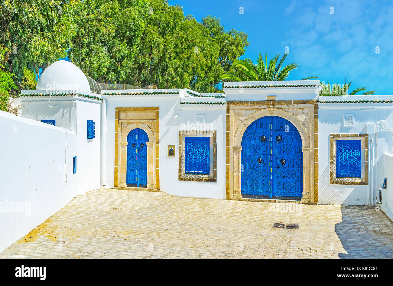 Hôtel particulier arabe historique à Sidi Bou Said avec des murs blancs et bleus lumineux, portes décorées de motifs islamiques, créé à partir de rivets, tun Banque D'Images