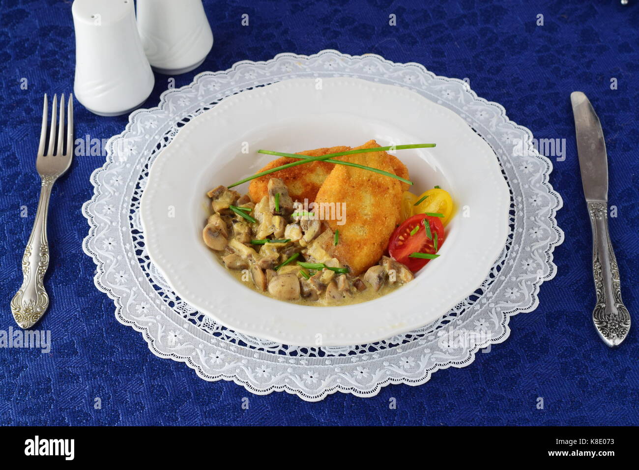 Galettes de pommes de terre avec sauce crémeuse aux champignons dans une assiette blanche sur un tissu bleu. concept d'aliments sains Banque D'Images