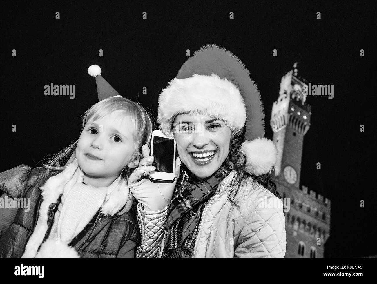 Voyage plein d'inspiration à l'époque de Noël à Florence. portrait de jeune mère et l'enfant les touristes à Noël chapeaux dans l'avant du palais Banque D'Images