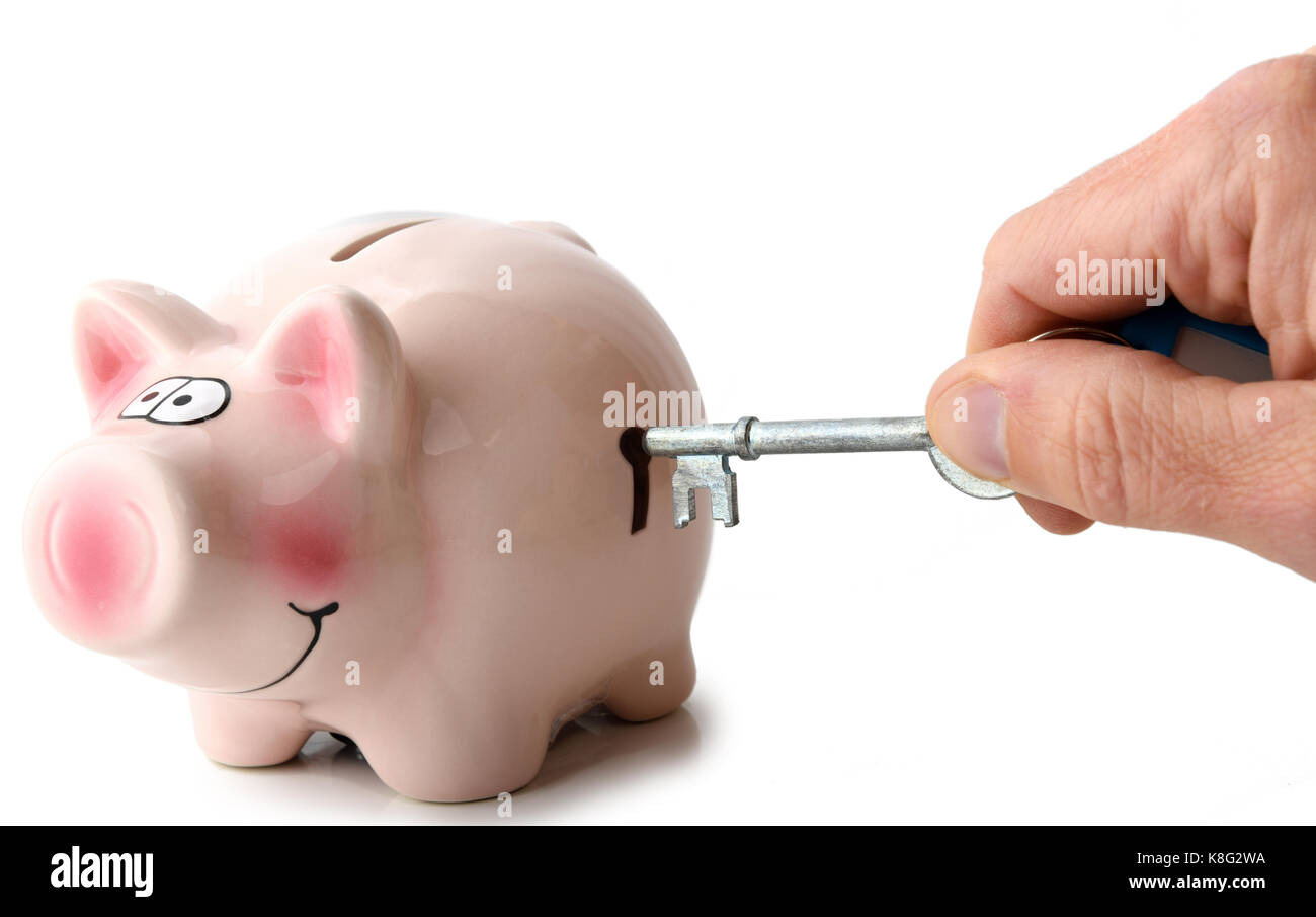 Concept de l'épargne, déverrouillage Déverrouillage d'une clé tirelire isolé sur fond blanc Banque D'Images