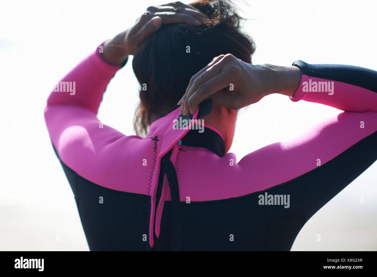 Vue arrière de l'épaule et tête de femme mature paddleboarder vétement de fixation Banque D'Images