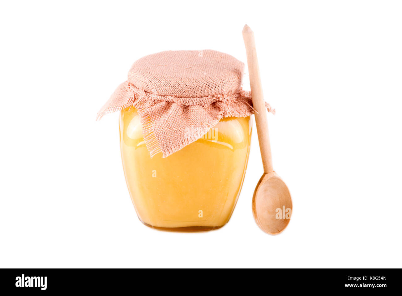 Pot de miel et une cuillère sur un fond blanc Banque D'Images