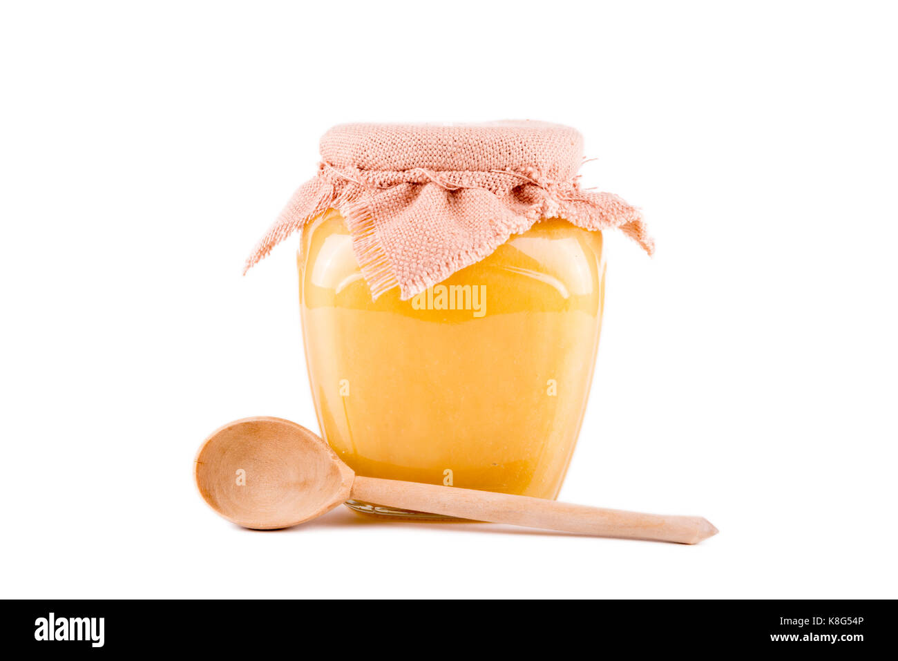 Pot de miel et une cuillère sur un fond blanc Banque D'Images