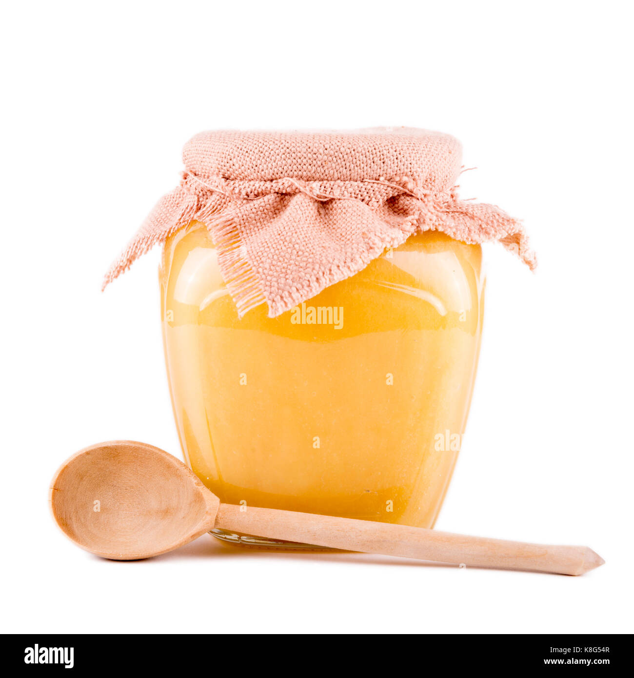Pot de miel et une cuillère sur un fond blanc Banque D'Images