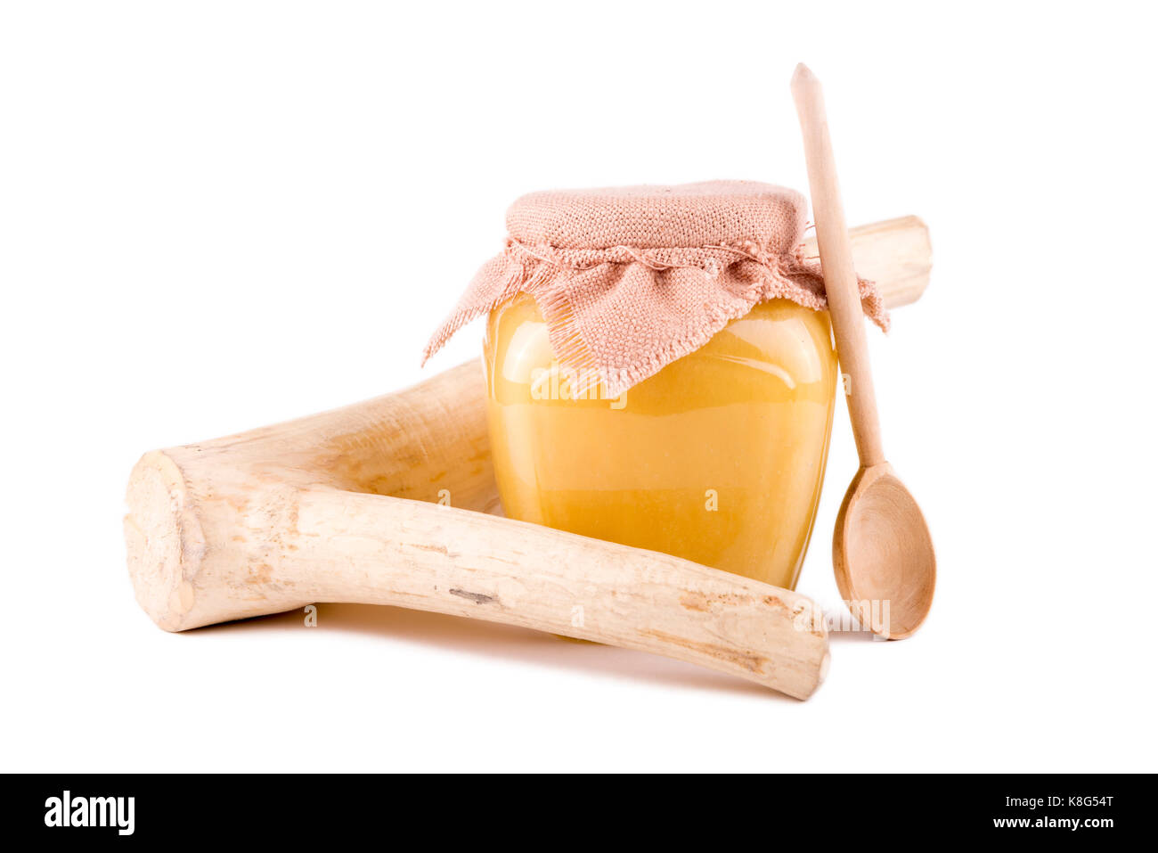 Pot de miel et une cuillère sur un fond blanc Banque D'Images