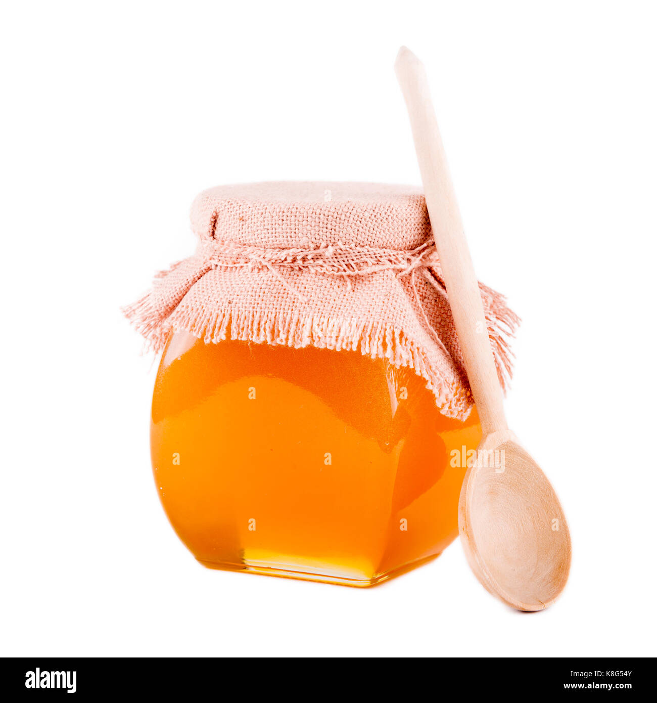 Pot de miel et une cuillère sur un fond blanc Banque D'Images