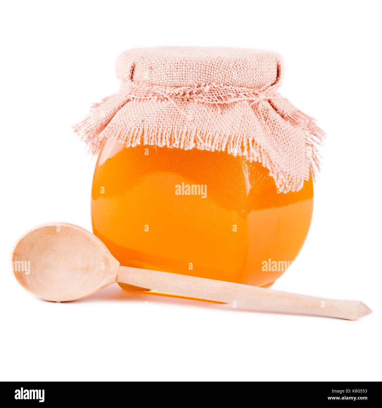 Pot de miel et une cuillère sur un fond blanc Banque D'Images