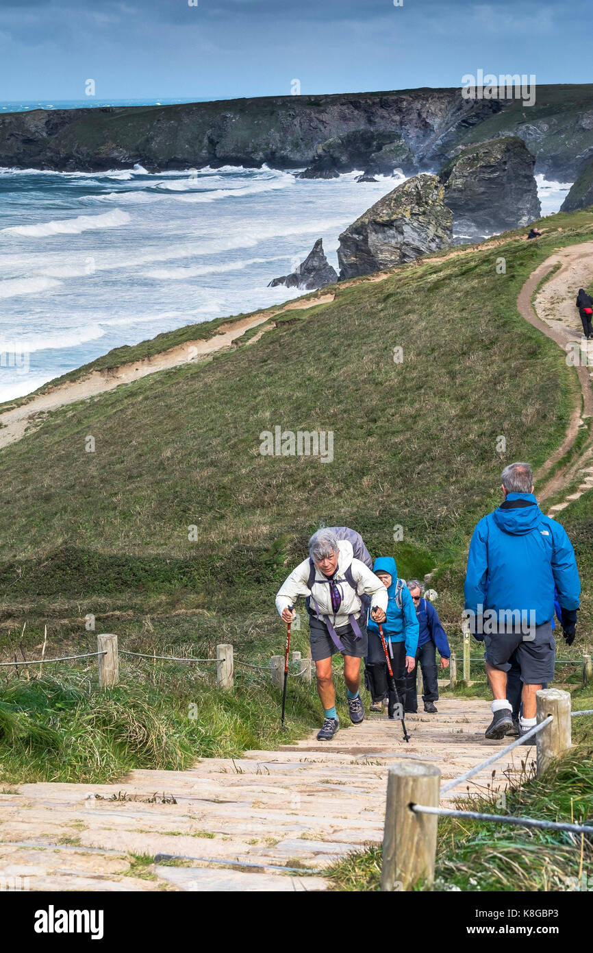 Bedruthan Steps - Walkers grimper des marches sur le South West Coast Path au Bedruthan Steps sur la côte nord des Cornouailles. Banque D'Images