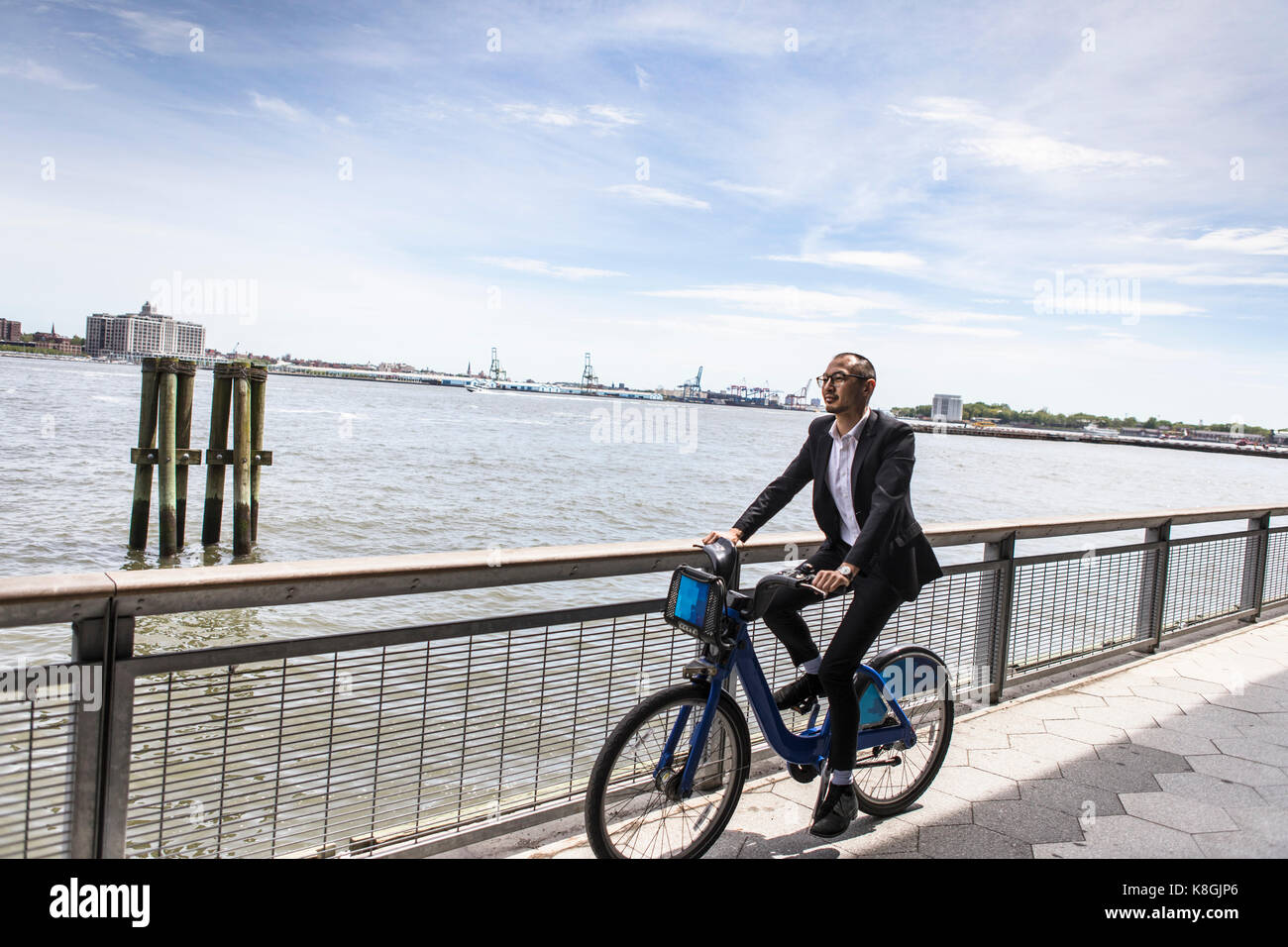 Mid adult businessman randonnée à vélo le long du fleuve de la ville Banque D'Images