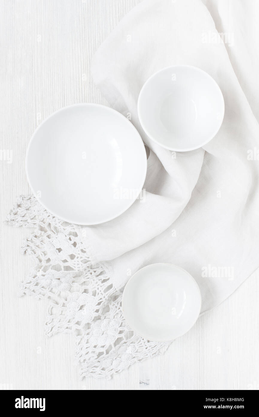 Les plaques blanches vides sur la table en bois clair avec serviette vintage Banque D'Images