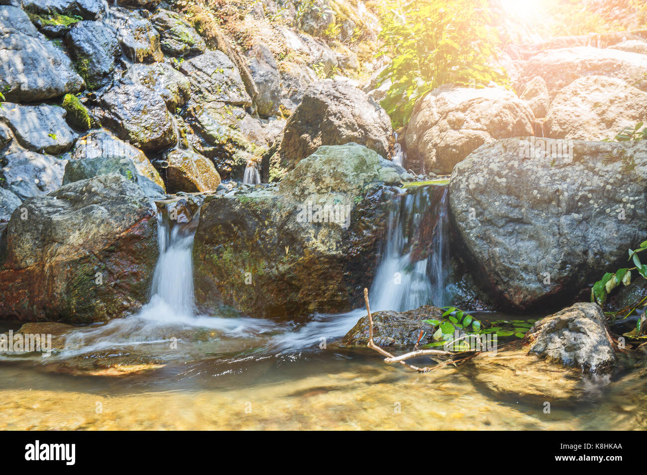 Petite cascade dans le jardin avec la lumière du soleil. Banque D'Images