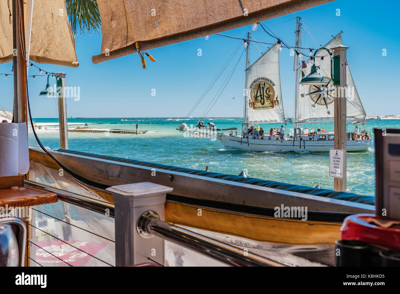 Vue du col avec un voilier de passage, en Floride, du Destin T Harry's restaurant, au port de plaisance de loisirs Harborwalk. Banque D'Images