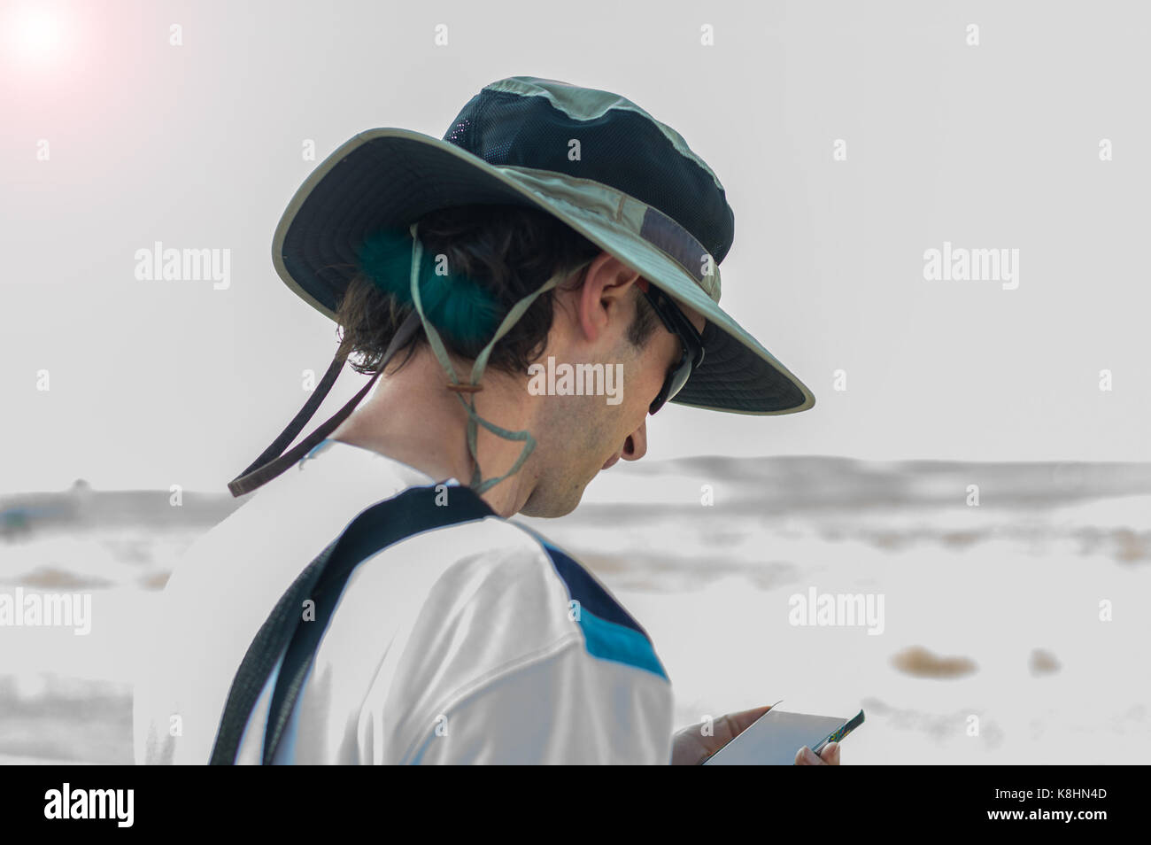 Young caucasian man with hat contrôler son téléphone portable à l'extérieur. Banque D'Images