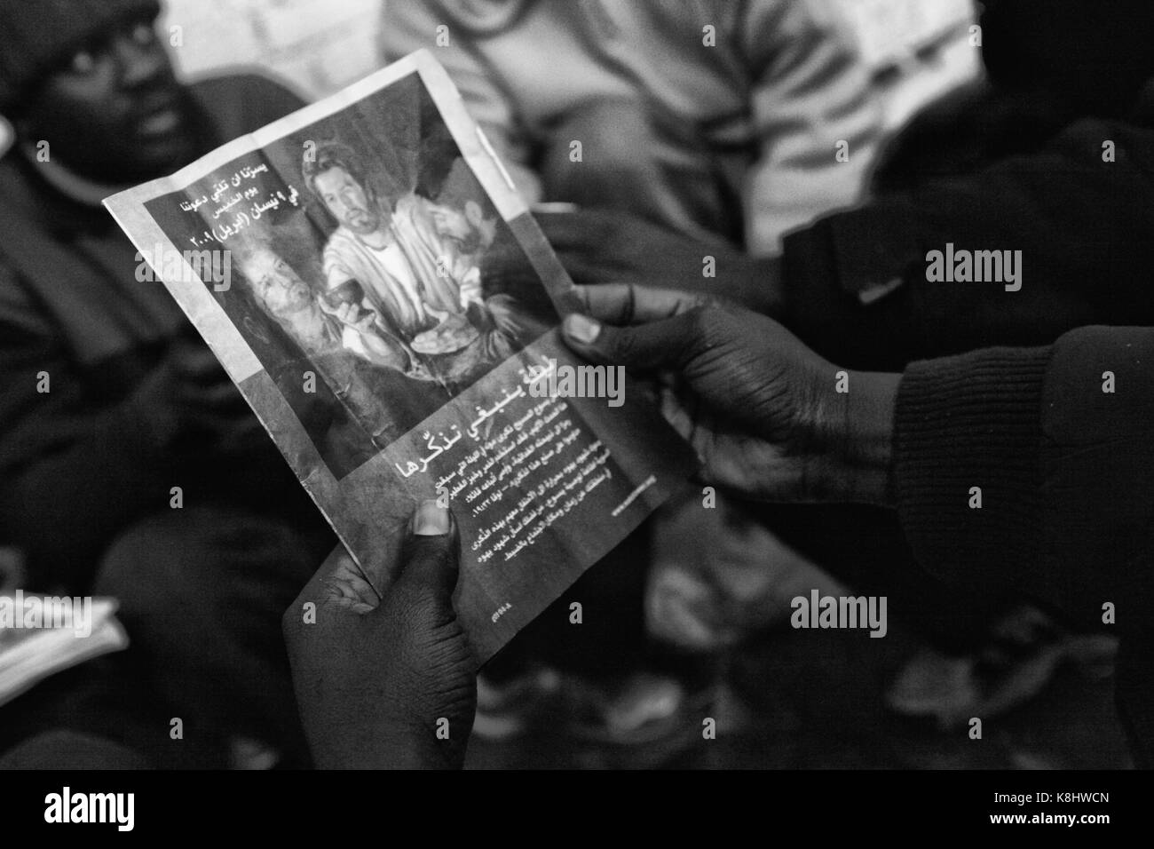 D'asile soudanais regardez une brochure chrétienne dans un entrepôt désaffecté, illégale appelée "Africa House" à Calais, France le 16 mars 2010. Afr Banque D'Images