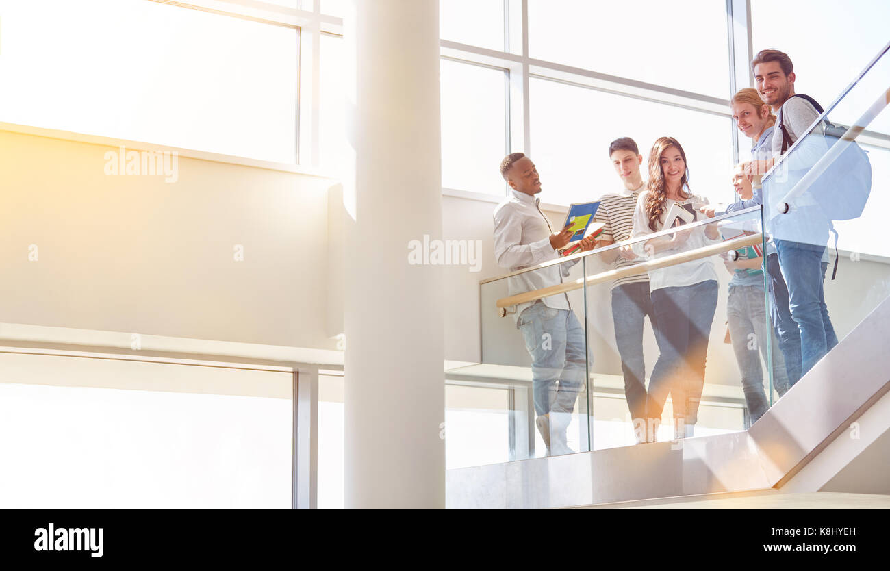 Comme les étudiants ont d'amis pause dans l'escalier de l'université Banque D'Images