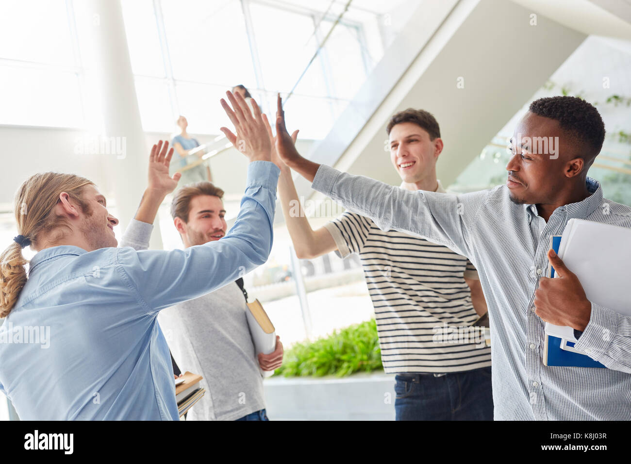 Les élèves partagent des cinq comme l'interracial team building groupe réussi Banque D'Images