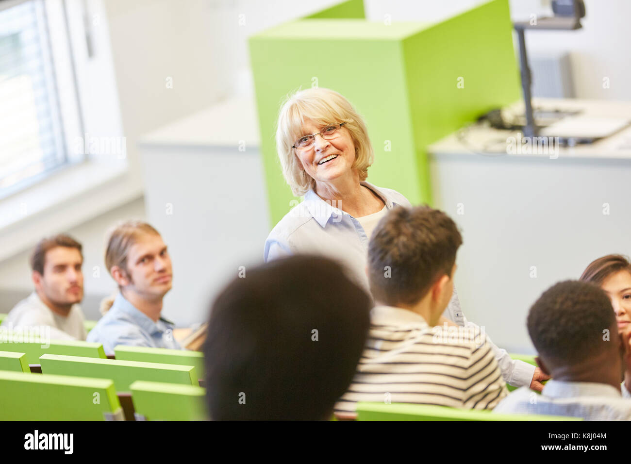 La femme comme professeur principal dans la classe avec les élèves de séminaire Banque D'Images