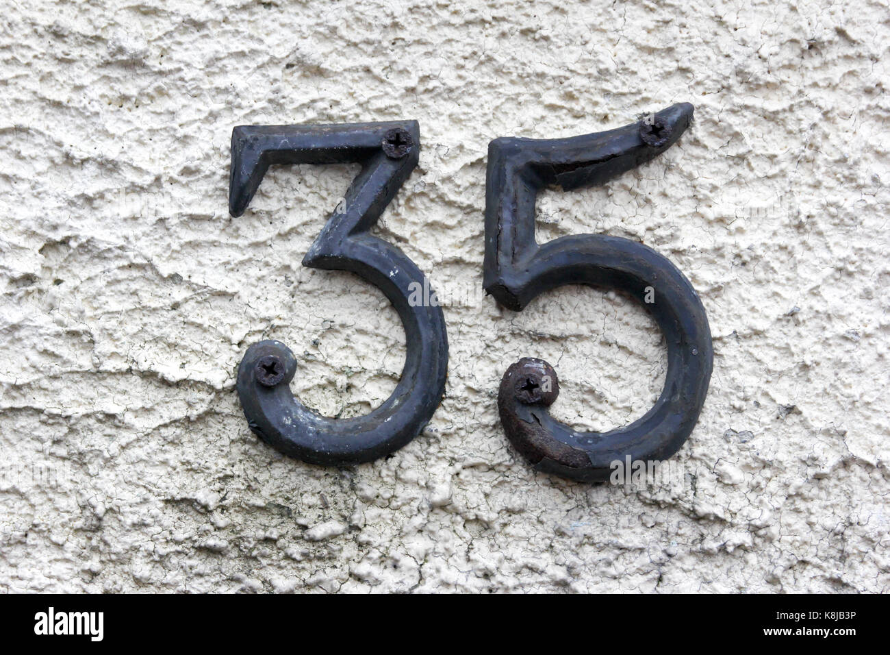 Le nombre 35 en métal vissé sur un mur Banque D'Images