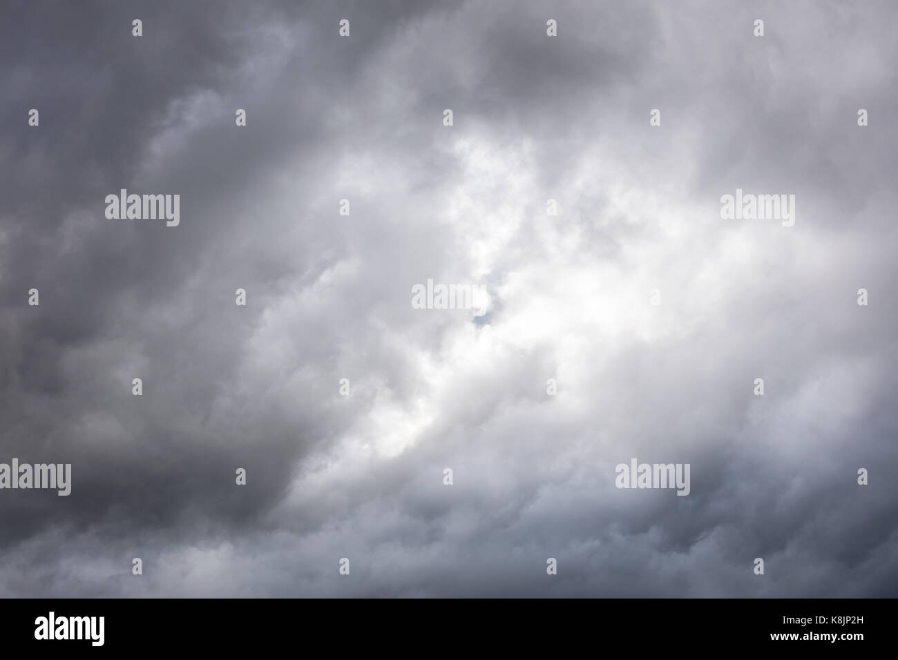 Ciel gris avec des nuages sombres et la lumière brille à travers eux. jour de pluie. Banque D'Images