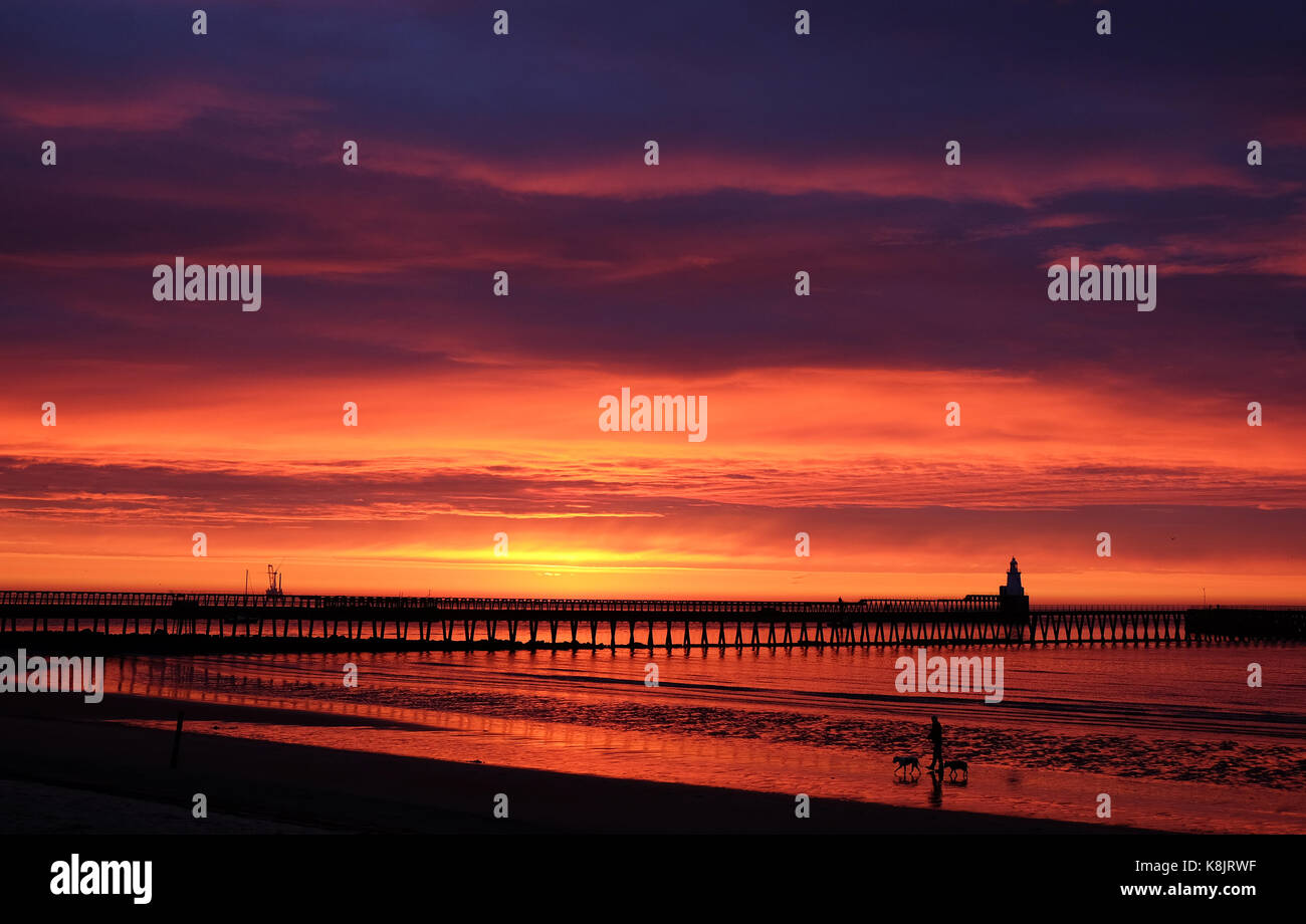 Le feu du ciel comme à l'aube sur le port de Blyth sur la côte de Northumberland. Banque D'Images