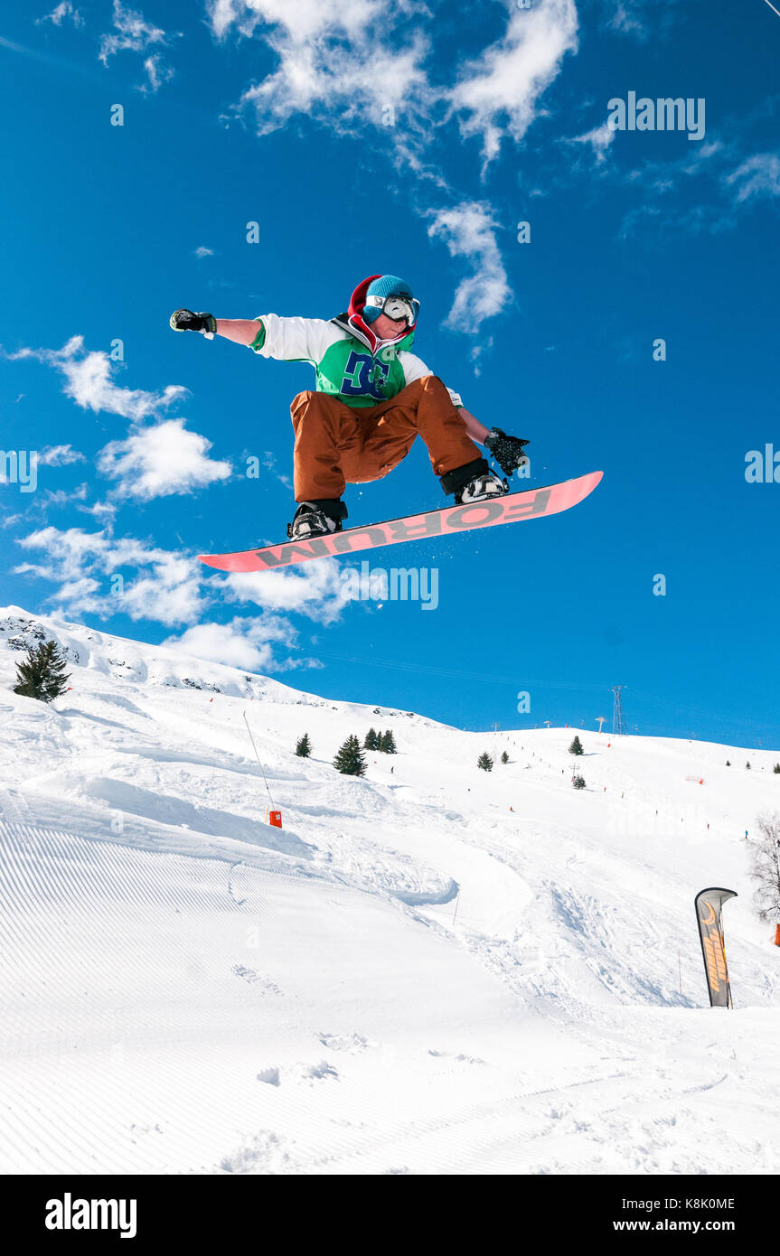 Snowboarder Jumping off ramp dans la neige à l'air, station de ski des 3 Vallées, Meribel, France Banque D'Images