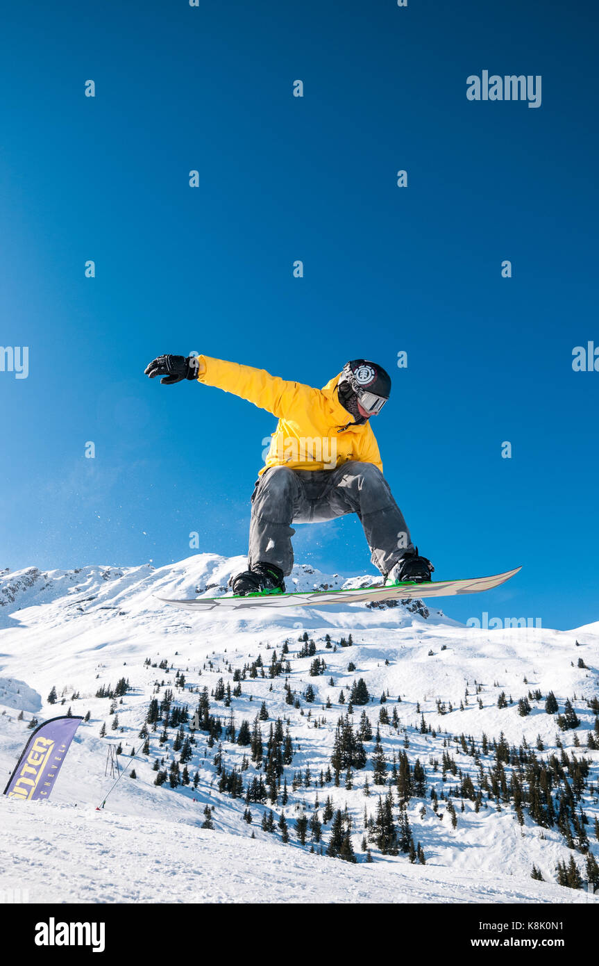 Snowboarder Jumping off ramp dans la neige à l'air, station de ski des 3 Vallées, Meribel, France Banque D'Images