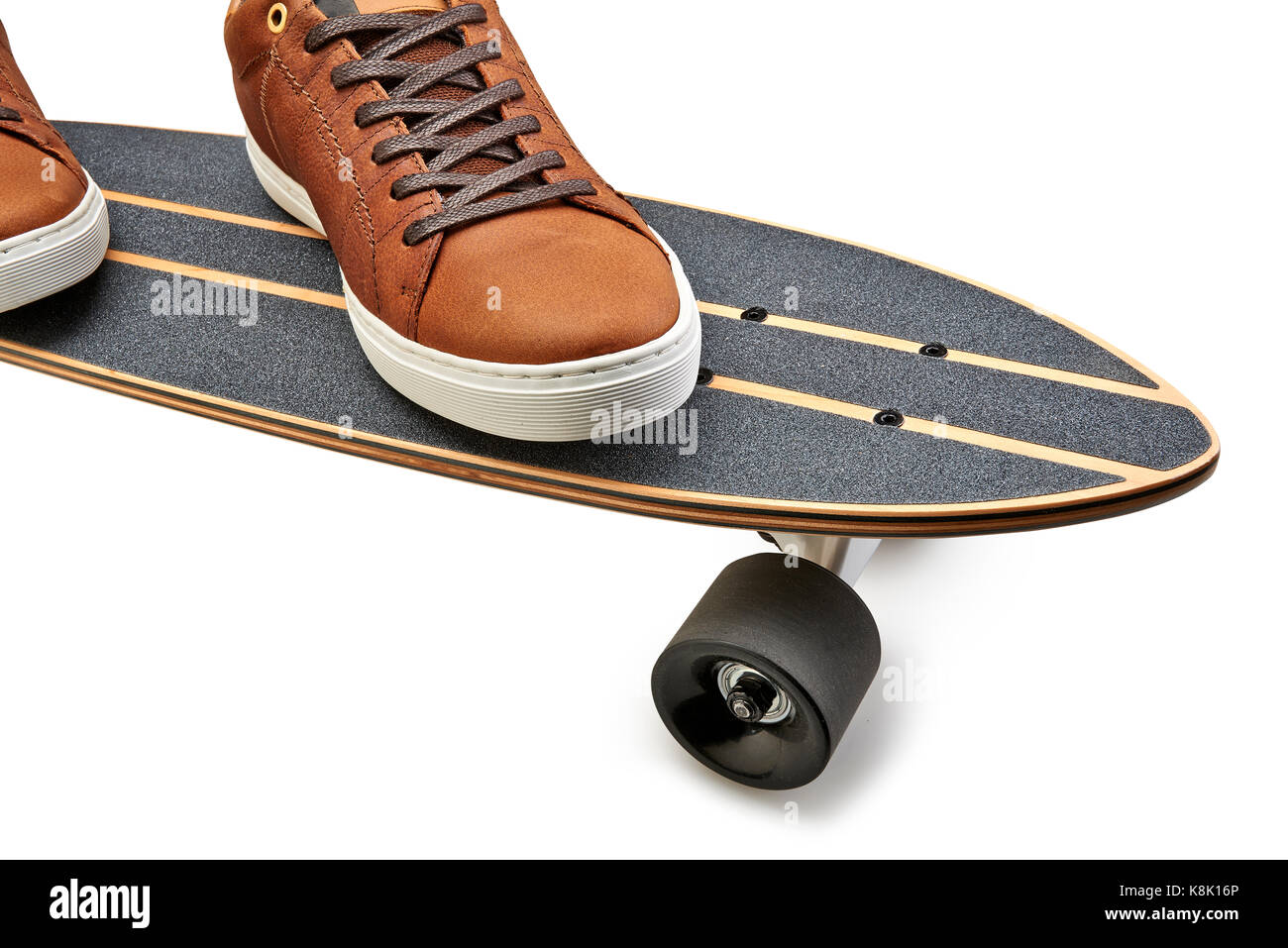 Vue latérale d'une dynamique et de skate board en bois noir et marron chaussures cuirs isolé sur un fond blanc avec clipping path Banque D'Images