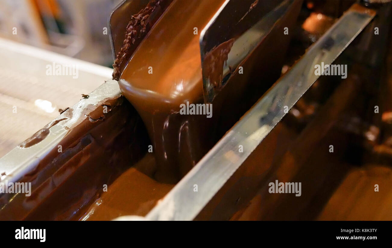Chocolat chaud liquide sur le convoyeur de la confiserie Banque D'Images