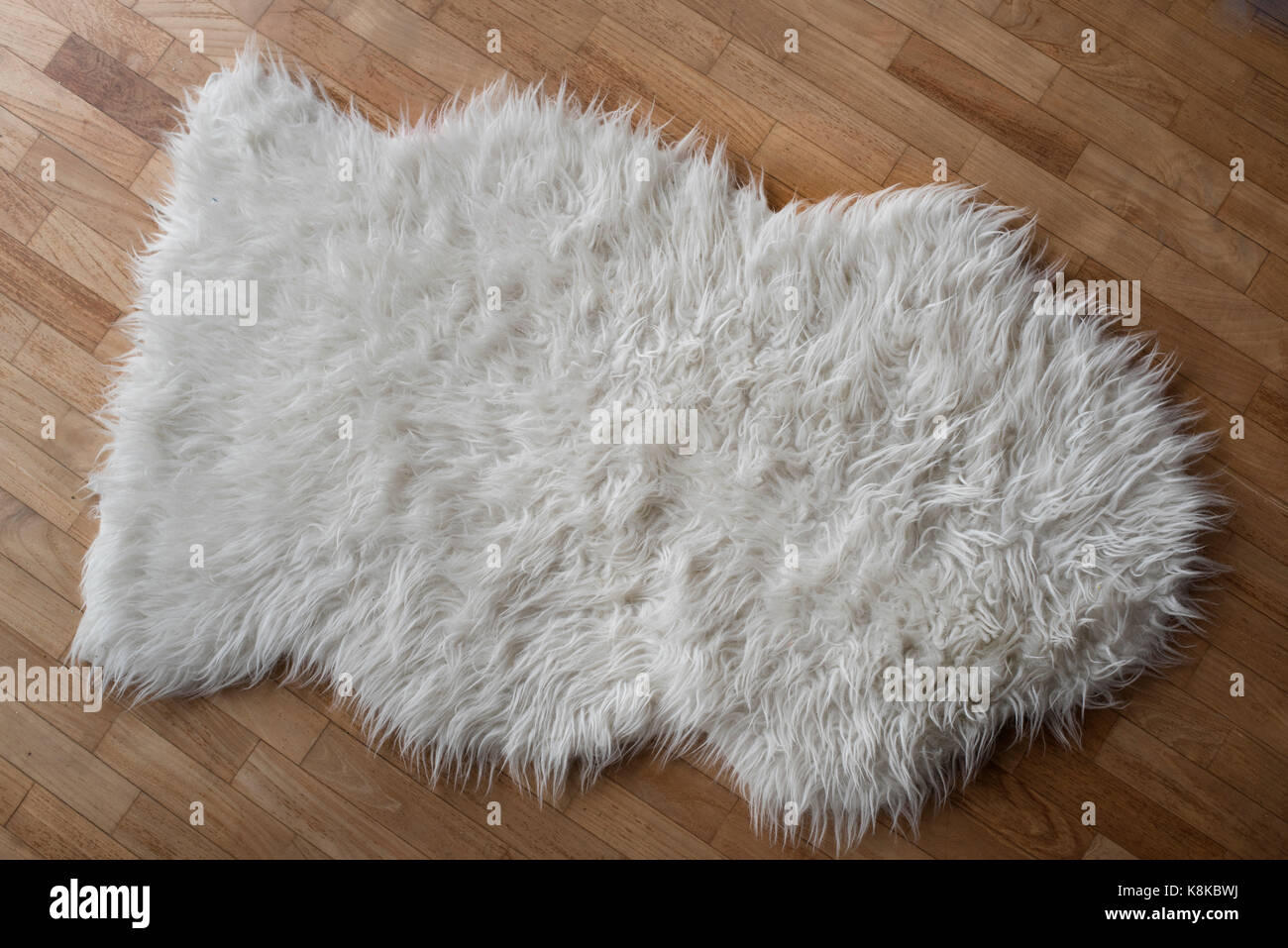 Photo d'un tapis en laine de mouton sur un sol en bois Banque D'Images