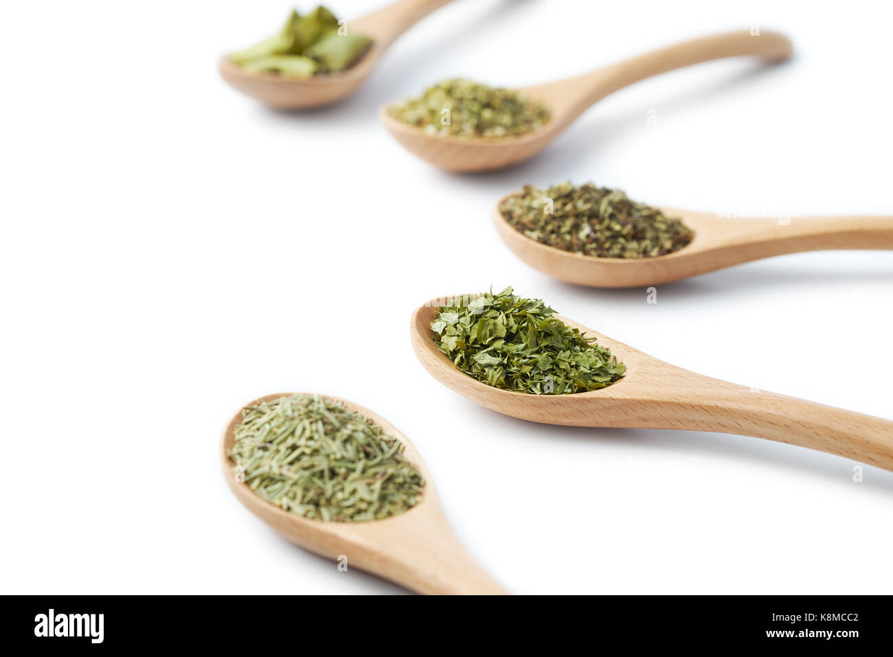 Cuillère en bois rempli d'herbes séchées sur fond blanc Banque D'Images