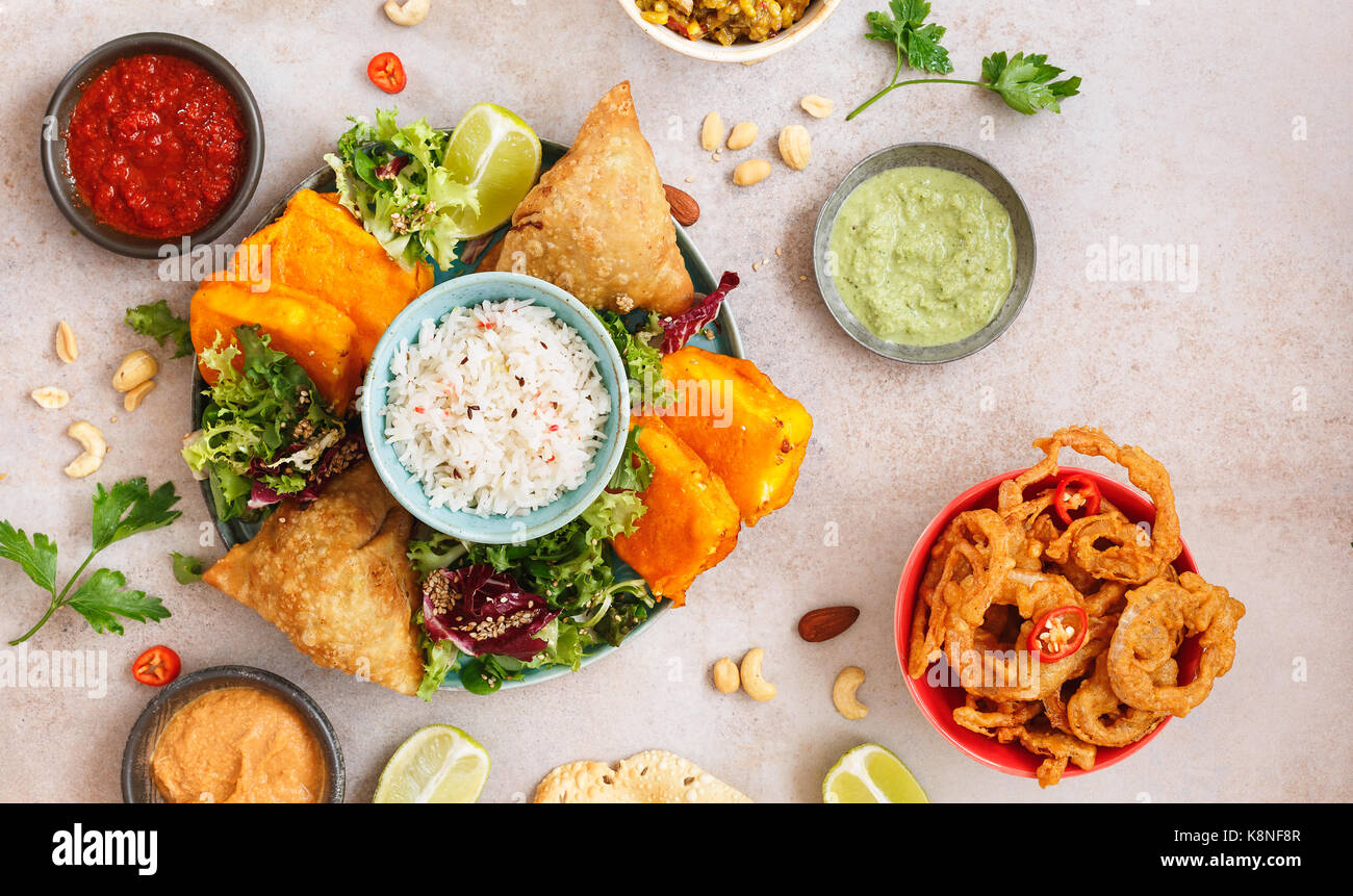 Thali indien végétarien épicé avec riz jeera, diverses salades et sauces sur surface rustique. Vue de dessus, l'espace vide Banque D'Images