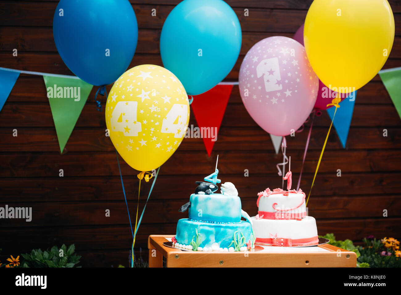 Gâteau d'anniversaire avec des bougies et des ballons en arrière-plan Banque D'Images
