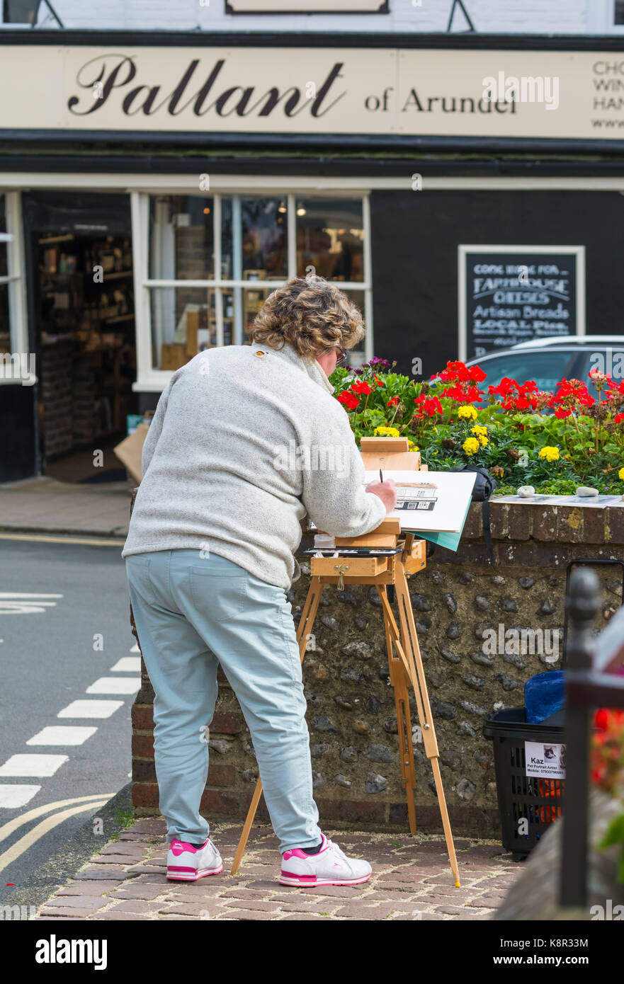 Artiste féminine en peinture d'un magasin local à l'aide de peinture et un chevalet à Arundel, West Sussex, Angleterre, Royaume-Uni. Banque D'Images Artiste féminine en peinture d'un magasin local à l'aide de peinture et un chevalet à Arundel, West Sussex, Angleterre, Royaume-Uni. Banque D'Images