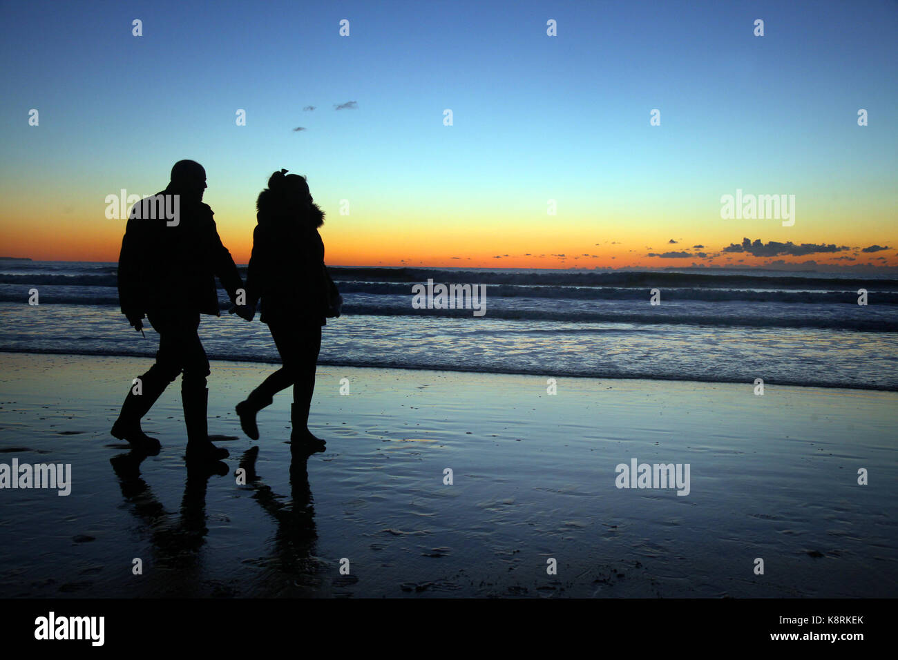 Un couple, faites une promenade le long de la plage de woolacombe pendant le coucher de soleil. woolacombe est l'une des meilleures plages au Royaume-Uni. Banque D'Images