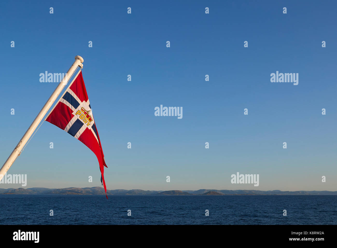 La poste norvégienne Drapeau Maritime, à partir de l'arrière du navire à passagers Hurtigruten, Mme Richard avec comme il navigue au nord vers le cercle arctique. Banque D'Images