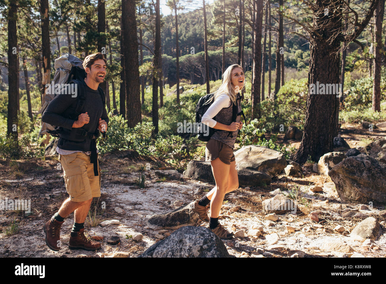 L'homme et la femme les randonneurs appréciant la randonnée sur sentier forestier. Explorer la nature couple randonneur marchant à travers les bois. Banque D'Images
