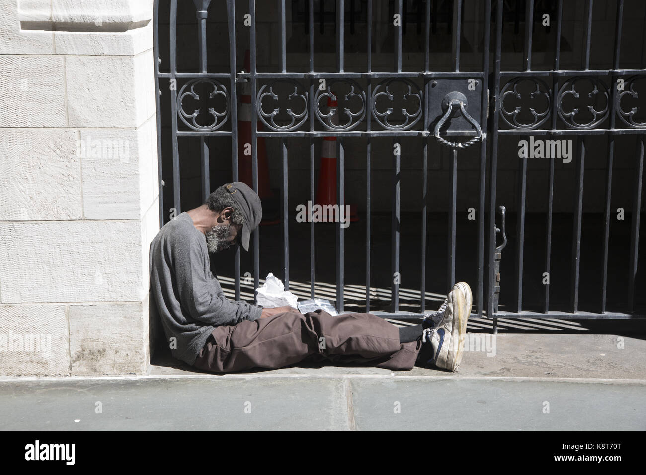 Sans-abri assis sur le trottoir à Midtown Manhattan. Banque D'Images