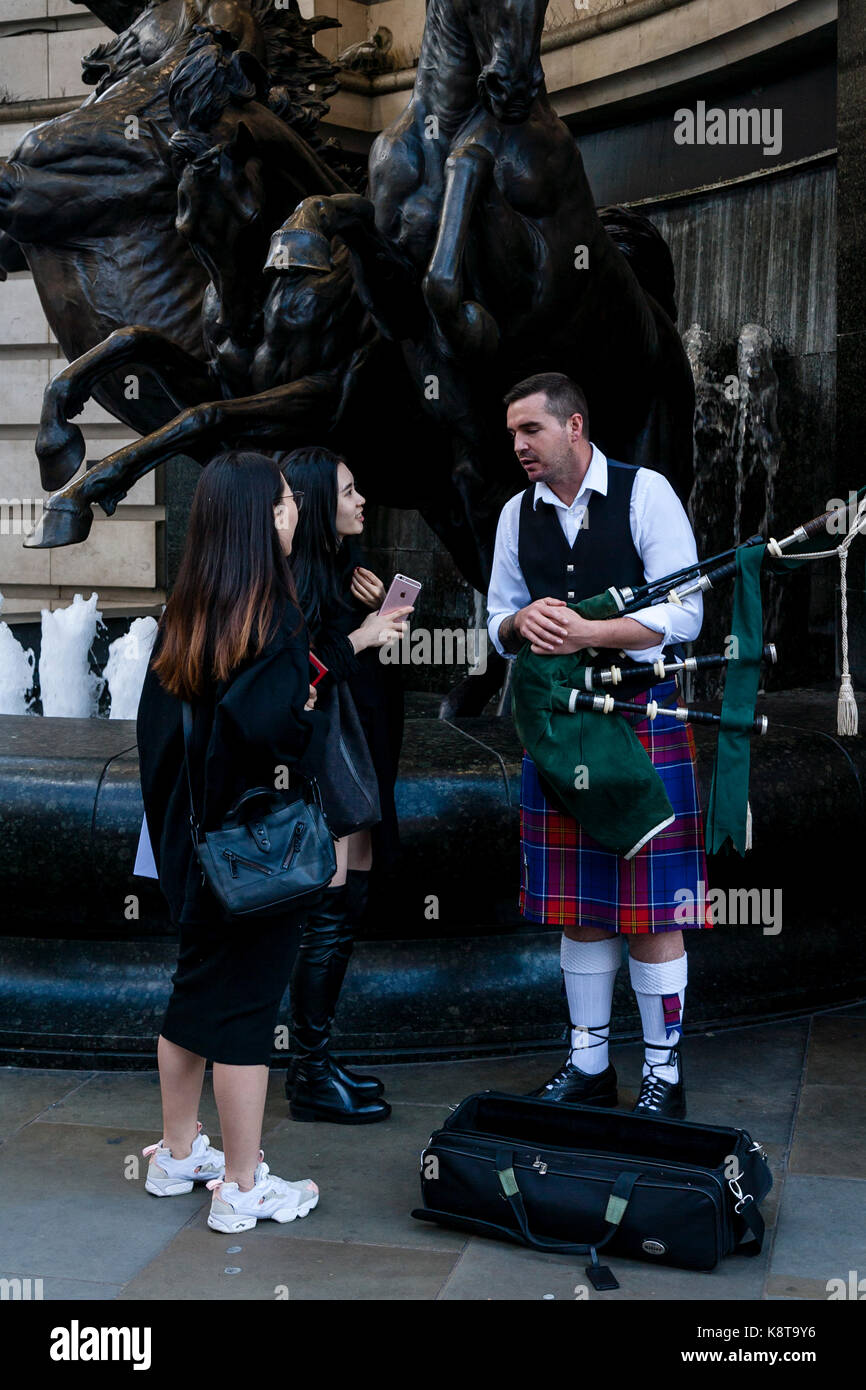 Les femmes qui discutent avec un artiste de rue, Piccadilly Circus, Londres, UK Banque D'Images