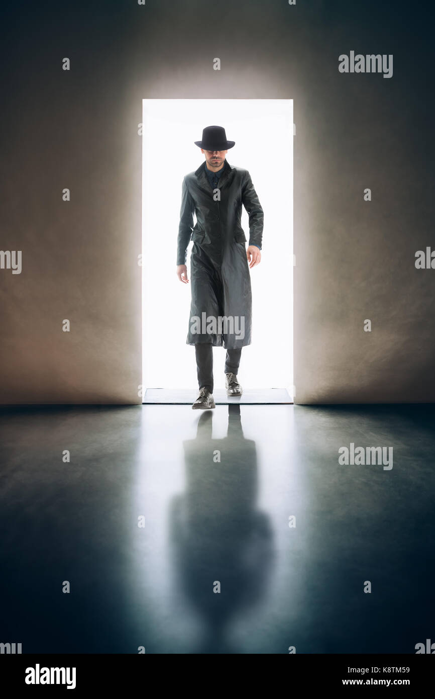 Silhouette homme venant de la lumière de l'ouverture de la porte dans une pièce sombre. concept mystère Banque D'Images