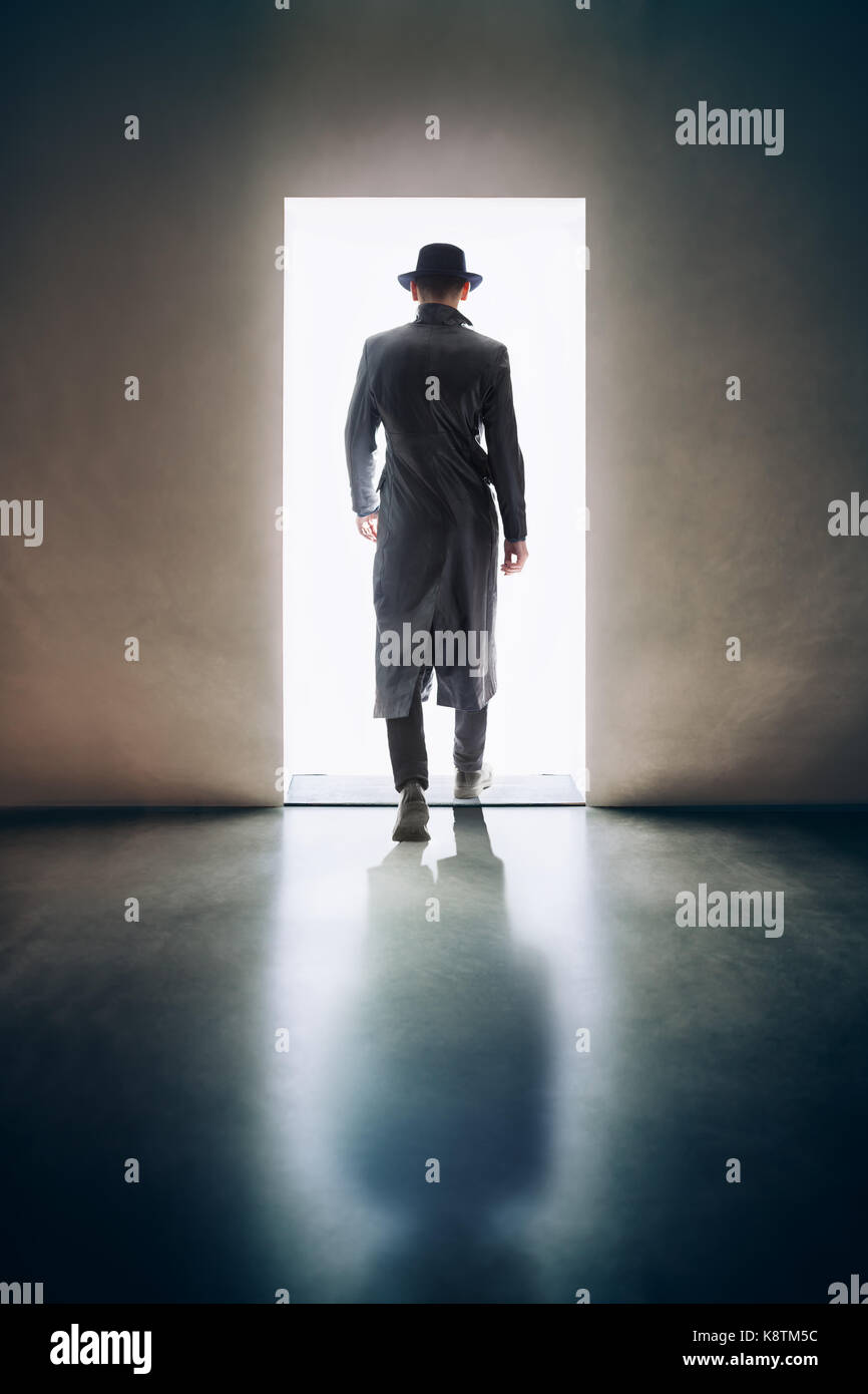 L'homme silhouette s'éloigner dans la lumière de l'ouverture de la porte dans une pièce sombre. escape concept Banque D'Images