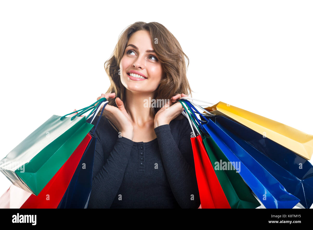 Young Beautiful woman holding shopping bags colorés de nombreux looking up isolé sur fond blanc Banque D'Images