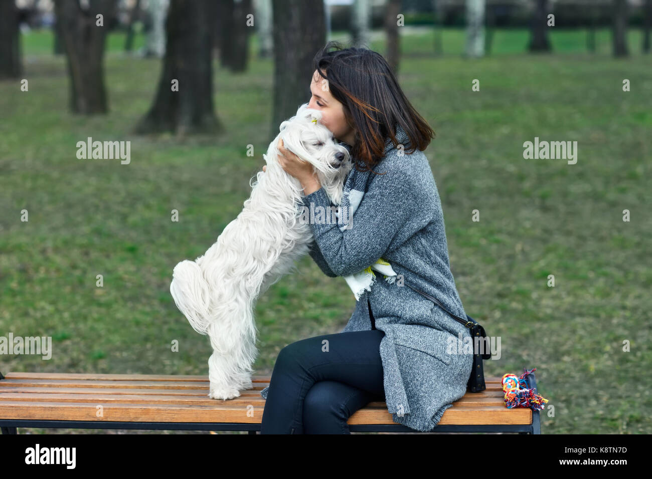 Propriétaire hugging et embrasser son mignon chien blanc. meilleur ami concept Banque D'Images