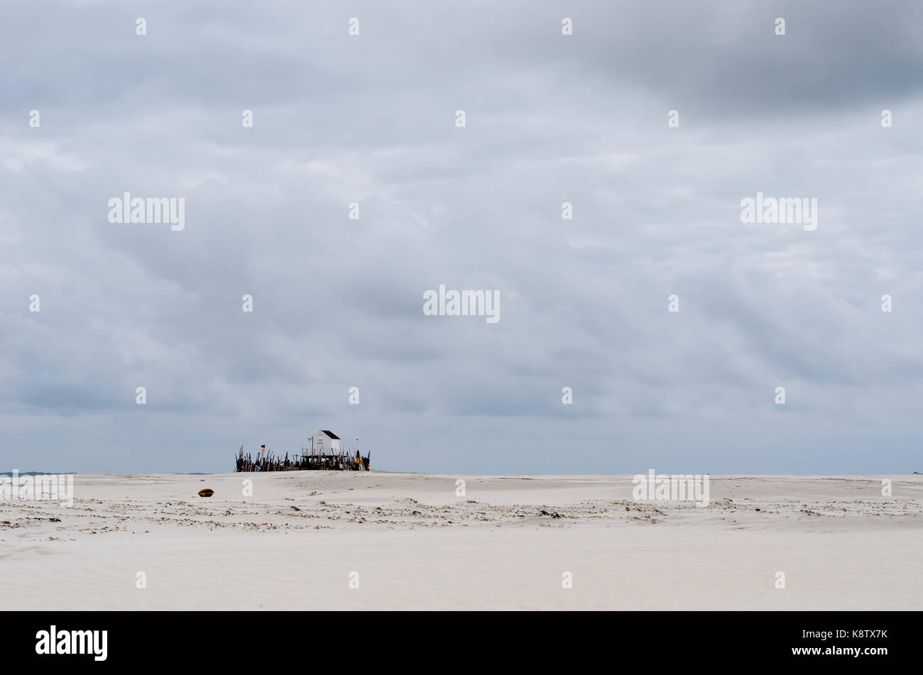 Beachcomber house sur une large plage de lonely et sur un jour nuageux Banque D'Images