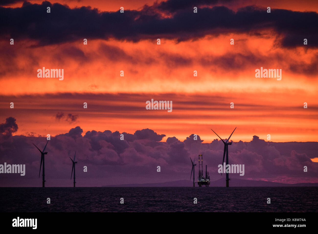 L'installation de l'ICM Seajacks Vestas Scylla aérogénérateurs) pendant le coucher du soleil sur le parc éolien de Walney Extension Banque D'Images