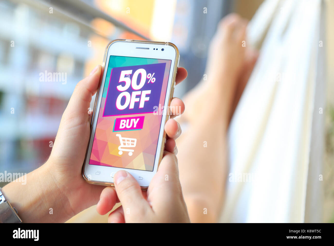 Femme dans un hamac avec un smartphone avec un rabais de 50  % de la publicité sur l'écran. Marketing, ecommerce, commode, le marketing par courriel, téléphone cellulaire. Banque D'Images