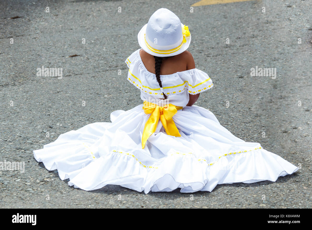 Petite fille dans l'habillement traditionnel du Costa Rica assis sur la rue Banque D'Images