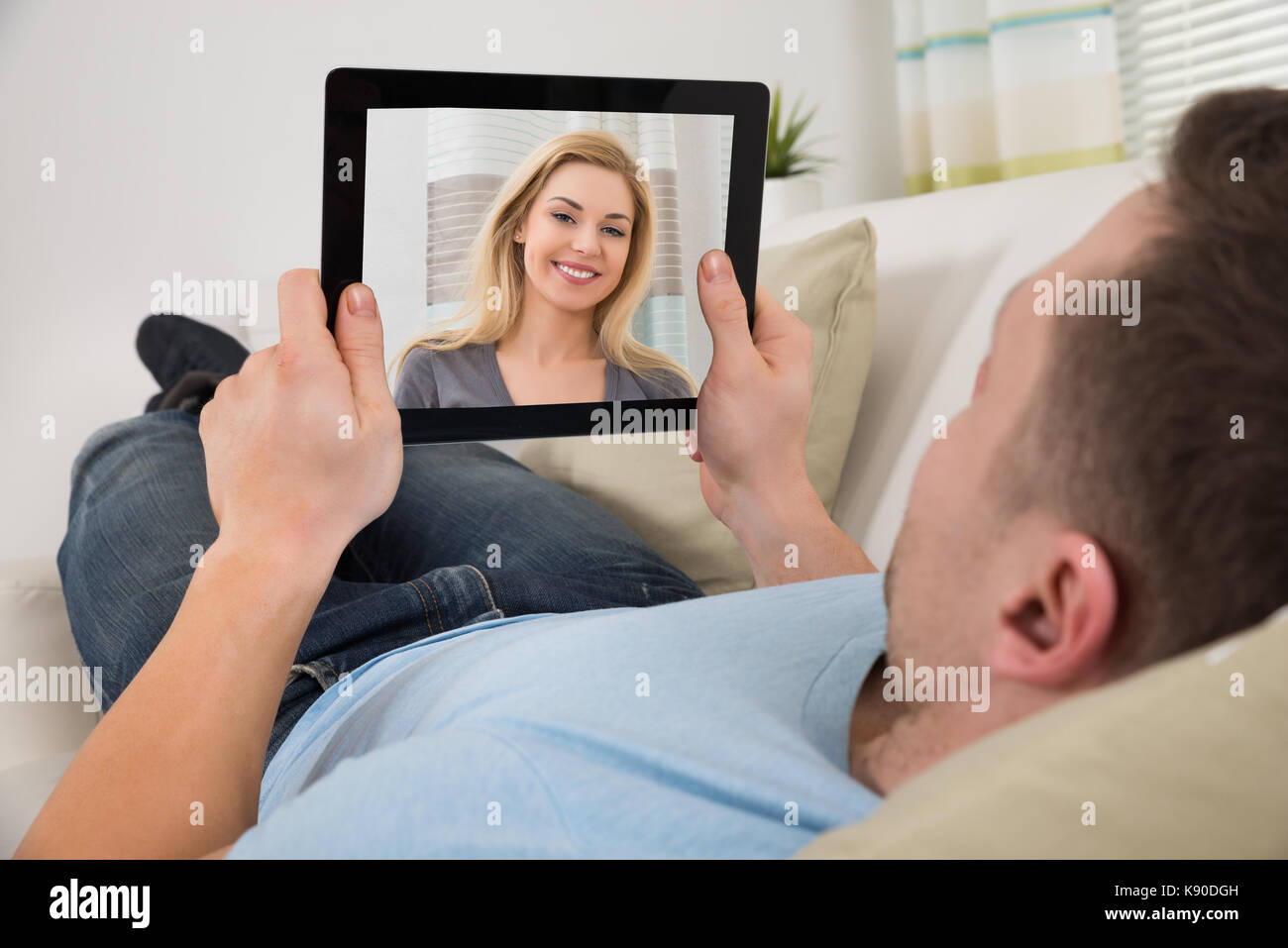 Mid adult man chat vidéo avec femme sur digital tablet Banque D'Images