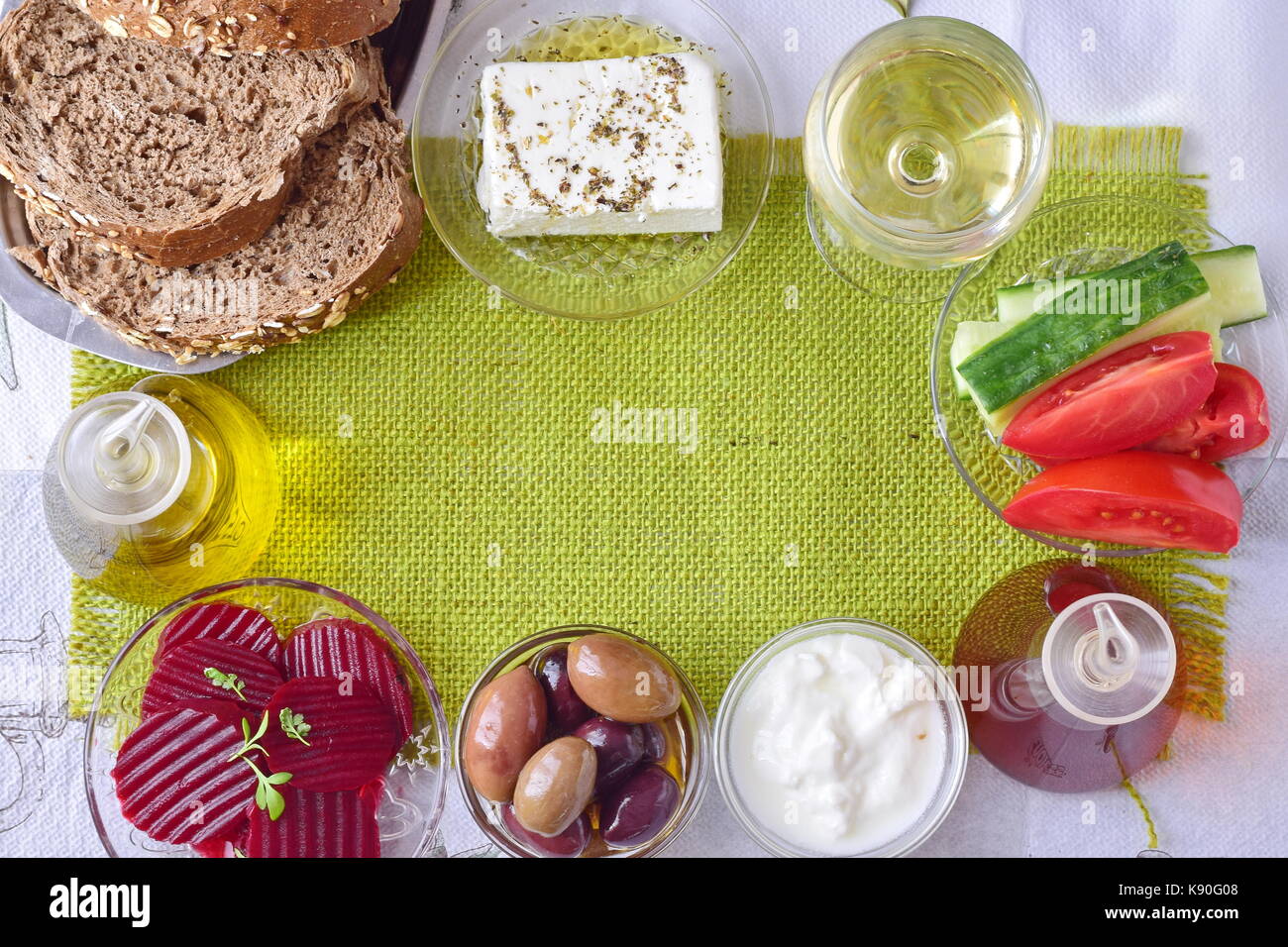 Fond de tissu vert avec l'espace pour un motif traditionnel méditerranéen. texte - fromage feta, tzatziki, les olives, l'ail,pot avec de l'huile d'olive, tomate, Banque D'Images